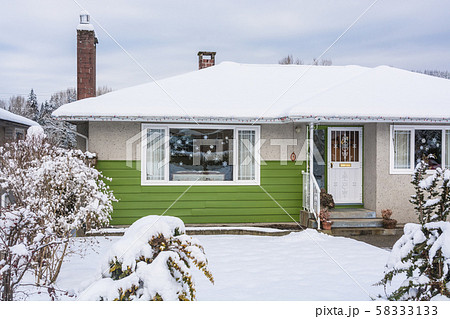 Colorful residential house in snow on winter cloudy day 58333133