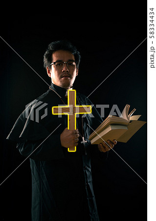 Priest show lighting crucifix while holding bible to exorcise ghost 58334434