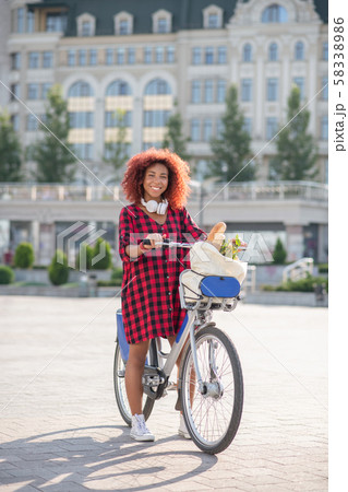 Curly woman feeling satisfied after going to supermarket 58338986