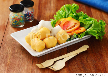 Fish balls with vegetables on dish, wooden spoon fork on wooden table. 58340739