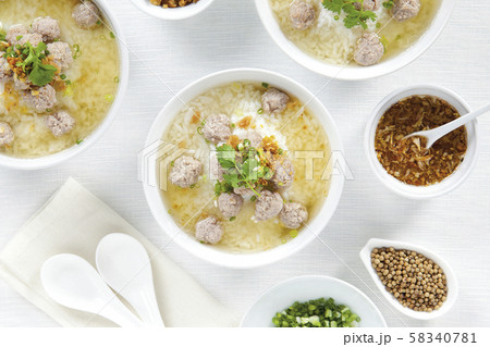 Rice porridge with pork chops and seasoning in white bowls on top view white table, Chinese food. 58340781