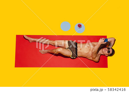 Top view of young caucasian male model's resting on beach resort Top view of young caucasian male model's resting on beach resort 58342416