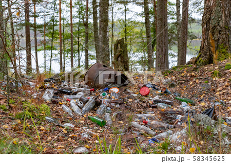 Pile of garbage left by tourists by the lake, environmental pollution concept Pile of garbage left by tourists by the lake, environmental pollution concept 58345625