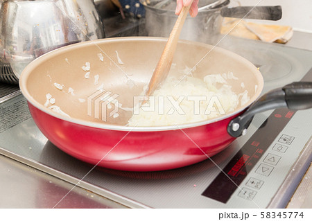 玉ねぎを炒める女性 58345774