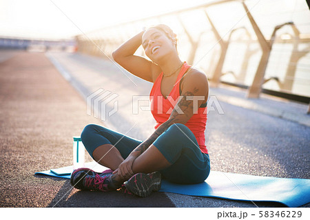Woman with tattoo on arm loving sport practicing yoga outside 58346229