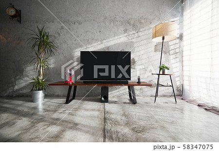 Modern living-room interior with TV in a loft style with wooden TV deck and concrete walls and floor . There are vintage fan and clock ,lamps and green plant to decorate . 58347075
