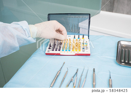 The dentists hand takes the endodontic obstructive 58348425