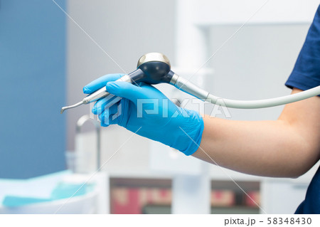 Close-up teeth airflow tool in the hand. 58348430