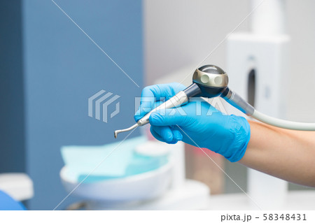 Close-up teeth airflow tool in the hand. 58348431