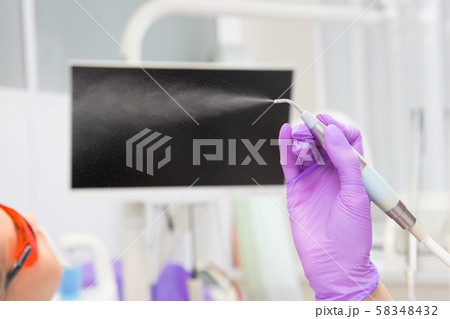 Close-up teeth airflow tool in the hand. 58348432