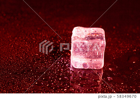 ice cubes on a reflections red light. 58349670