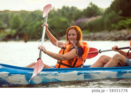 Caucasian woman kayaking on river with sunset on the background 58351776