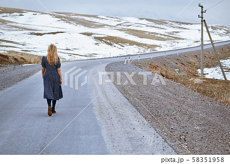 Woman walking along the rural highway Woman walking along the rural highway 58351958
