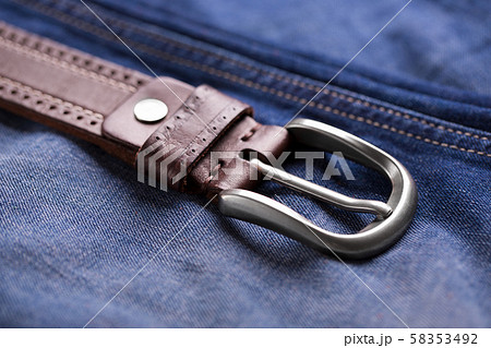 Leather belt close-up. Belt and blue jeans. 58353492