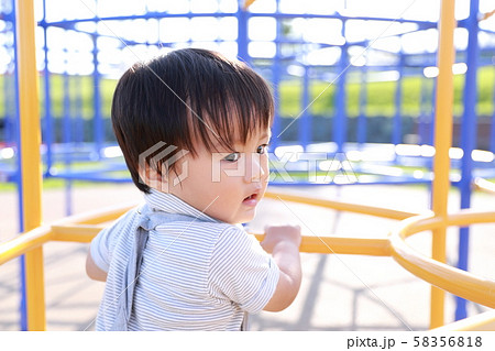 公園のアスレチックで遊ぶ2歳の男の子の写真素材