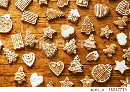 Ready Christmas gingerbread cookies in white sugar glaze lie on a wooden plane. 58357730