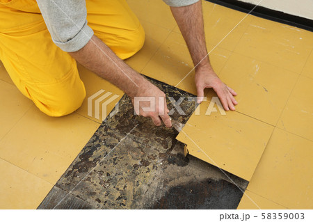 Old vinyl tiles removal from floor in a room or 58359003