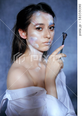 Creative fashion beauty portrait of a beautiful young woman with an artistic tassel in her hands. 58359390