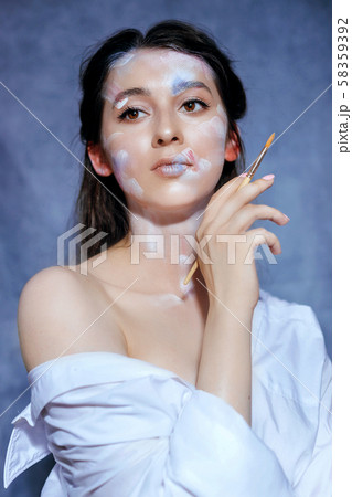 Creative fashion beauty portrait of a beautiful young woman with an artistic tassel in her hands. Creative fashion beauty portrait of a beautiful young woman with an artistic tassel in her hands. 58359392