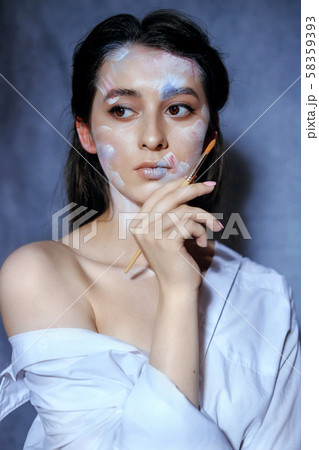 Creative fashion beauty portrait of a beautiful young woman with an artistic tassel in her hands. 58359393