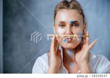 Creative fashion beauty portrait of a beautiful young blonde woman with an artistic tassel in her hands. 58359547