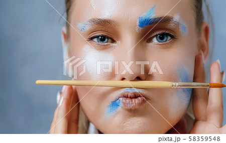 Creative fashion beauty portrait of a beautiful young blonde woman with an artistic tassel in her hands. Creative fashion beauty portrait of a beautiful young blonde woman with an artistic tassel in her hands. 58359548
