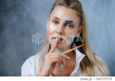 Creative fashion beauty portrait of a beautiful young blonde woman with an artistic tassel in her hands. Creative fashion beauty portrait of a beautiful young blonde woman with an artistic tassel in her hands. 58359550