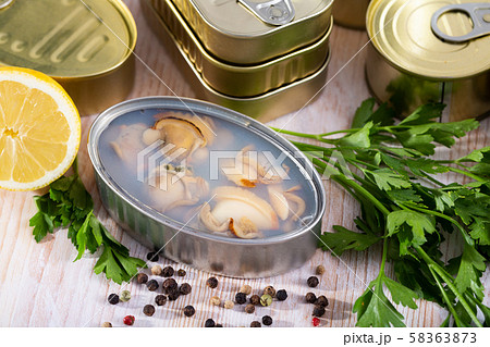 Open tin can with sea clams in its own juice Open tin can with sea clams in its own juice 58363873