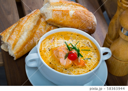 Creamy salmon soup with baguette 58363944