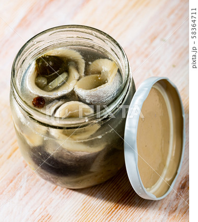 Glass jar with pickled herring 58364711
