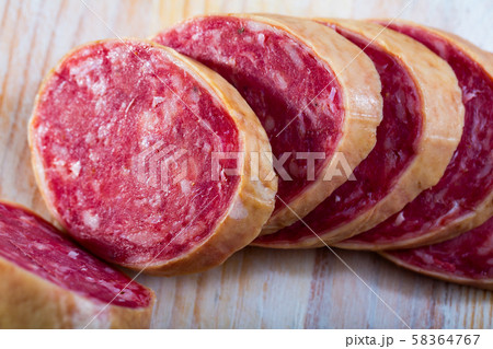 Salchichon spanish sausage slices on wooden desk 58364767