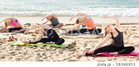 Smiling sporty women practicing yoga positions Smiling sporty women practicing yoga positions 58366953