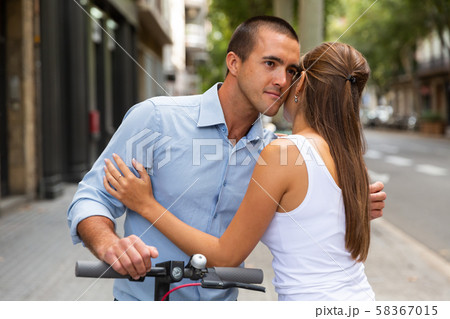 Hugging man and woman on electro scooter 58367015