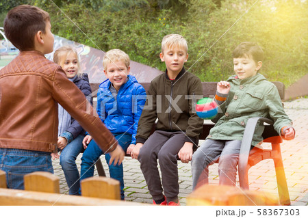 Children playing with ball on bench Children playing with ball on bench 58367303