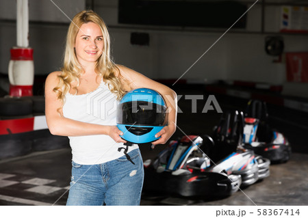 Pretty woman with helmet standing near cars Pretty woman with helmet standing near cars 58367414