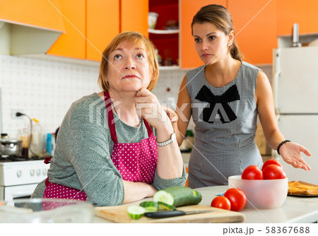 Upset senior woman during quarreling with young sad daughter Upset senior woman during quarreling with young sad daughter 58367688