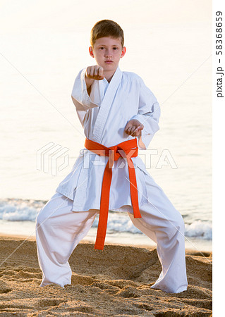Boy doing karate at ocean quay Boy doing karate at ocean quay 58368659