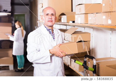 Worker performing loading works in storage Worker performing loading works in storage 58368835