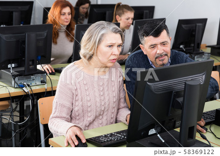 Mature man and woman learning to use computer 58369122