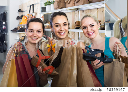 three girls holding a paper shopping bags in the boutique three girls holding a paper shopping bags in the boutique 58369167