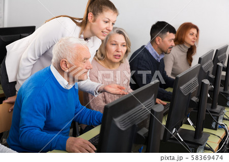Business woman helping to partners, pointing at computer monitor 58369474