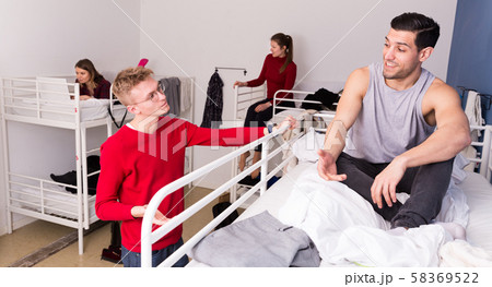 Male tourists communicating in hostel Male tourists communicating in hostel 58369522