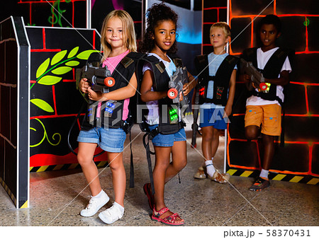 Two girls standing back to back with laser pistols Two girls standing back to back with laser pistols 58370431