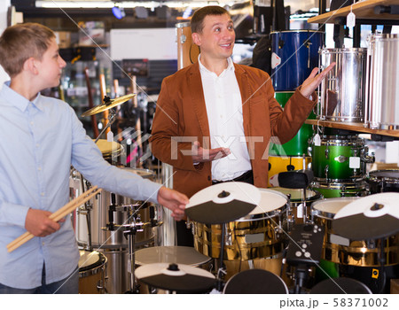 Boy and father choosing best drum 58371002