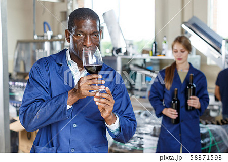 Winery worker testing new wine Winery worker testing new wine 58371593