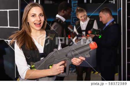 Fine woman and her colleagues in laser tag room 58372389