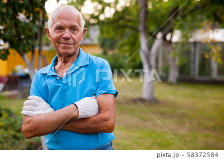 Portrait of positive mature farmer in his garden Portrait of positive mature farmer in his garden 58372584