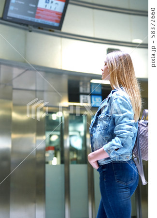Girl with long hair looks train schedule in the subway Girl with long hair looks train schedule in the subway 58372660