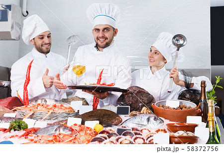 Smiling team of professional cooks of fish restaurant Smiling team of professional cooks of fish restaurant 58372756