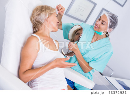 Cosmetician explaining treatment to patient Cosmetician explaining treatment to patient 58372921